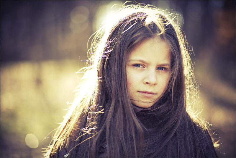 Primer plano de niña con expresión de enfado y labios apretados; conducta desafiante asociada al trastorno negativista desafiante.