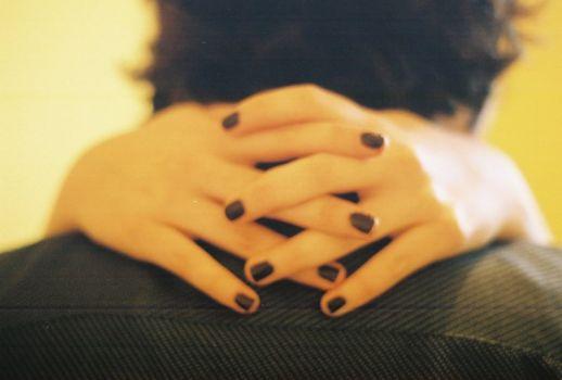 Primer plano de un abrazo con manos entrelazadas sobre la nuca