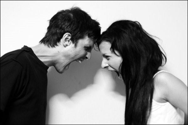Pareja frente a frente gritando en blanco y negro; imagen que representa un conflicto de pareja y problemas de comunicación.